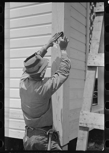 Untitled photo, possibly related to: Southeast Missouri Farms Project. Finishing off corner board of one of the new houses