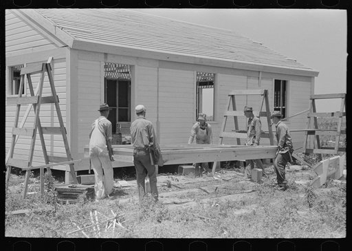 Southeast Missouri Farms Project. House erection. Shop-assembled porch floor being lifted into position
