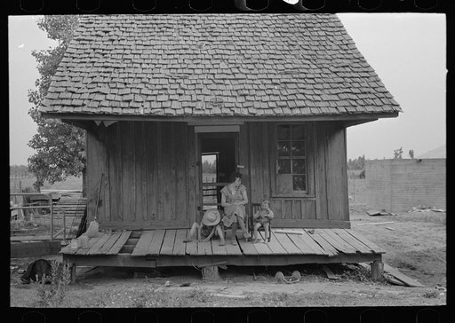 Untitled photo, possibly related to: Front of sharecropper cabin. Note absence of posts holding up roof. Southeast Missouri Farms