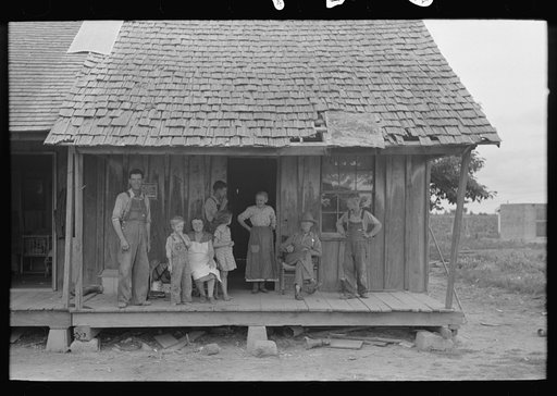Untitled photo, possibly related to: Sharecropper family on front porch of cabin, Southeast Missouri Farms