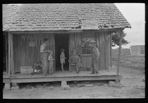 Untitled photo, possibly related to: Sharecropper family on front porch of cabin, Southeast Missouri Farms