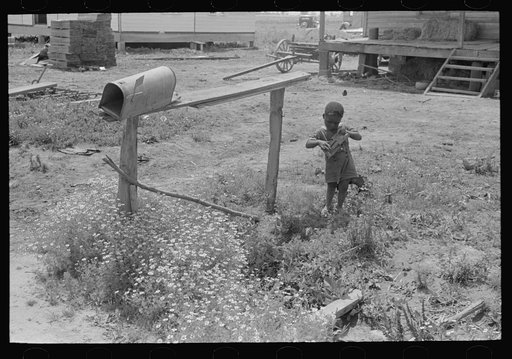 Child playing with toy near mailbox, Southeast Missouri Farms