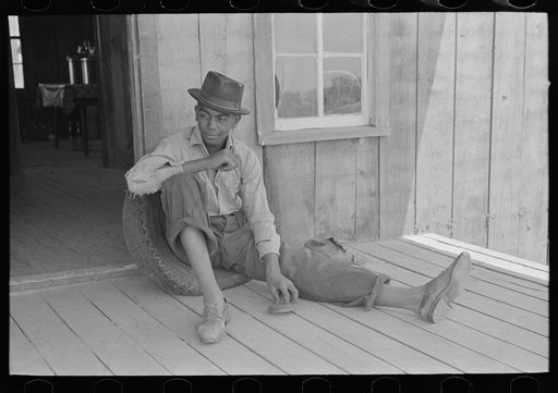 Son of sharecropper on front porch of shack home, Southeast Missouri Farms