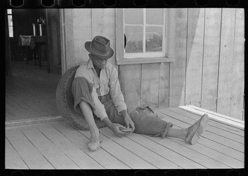 Untitled photo, possibly related to: Son of sharecropper on front porch of shack home, Southeast Missouri Farms