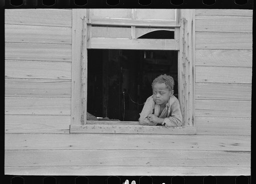 Son of sharecropper in window of old home, Southeast Missouri Farms