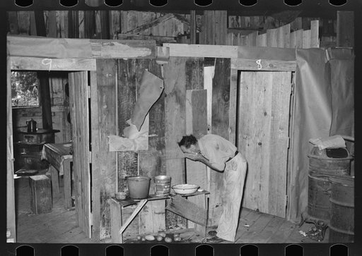 Squatter washing face in abandoned warehouse, Carutherville, Missouri. This warehouse was used during the height of the river steamboat era as passenger and freight station