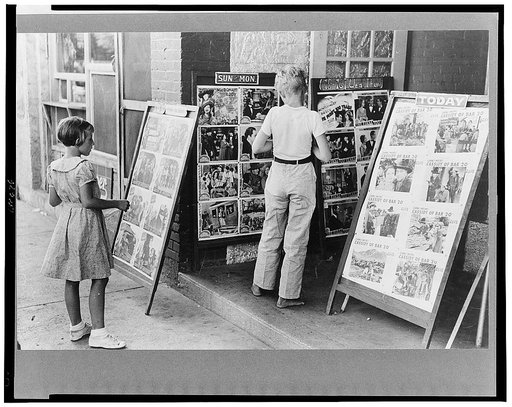 Children looking at posters in front of movie, Saturday, Steele, Missouri