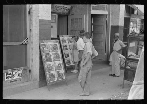 Children looking at posters in front of movie, Saturday, Steele, Missouri