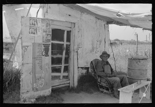 Resident of "Tin Town" sitting in front of his shack home, Caruthersville, Missouri