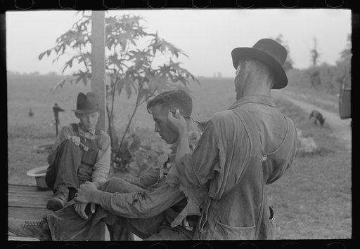 Farmer cutting his brother's hair, near Caruthersville, Missouri