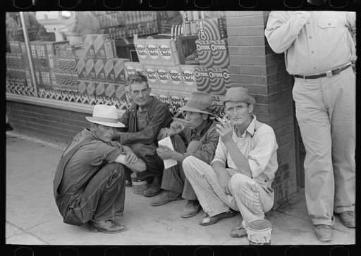 Farmers squatting on sidewalk, Caruthersville, Missouri