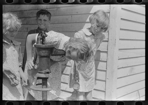 Schoolchildren drinking from the water pump, Southeast Missouri Farms