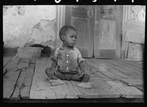 Negro child on porch of dilapidated Trepagnier plantation near Norco, Louisiana
