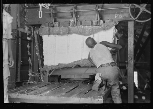 Untitled photo, possibly related to: Putting steel straps in place to hold pressed cotton after pressure has been removed, Lehi, Arkansas cotton gin