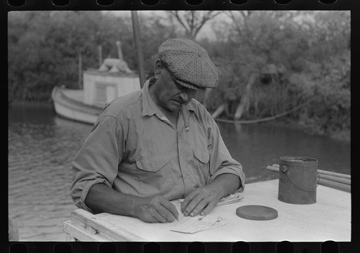Untitled photo, possibly related to: Oyster shipper making out tags to be attached to bags of oysters, Olga, Louisiana