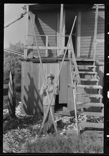 Untitled photo, possibly related to: Boy with oyster rake used for scooping oysters in fishing operations, Olga, Louisiana