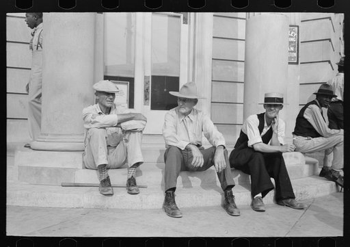 Men sitting on bank steps during National Rice Festival, Crowley, Louisiana