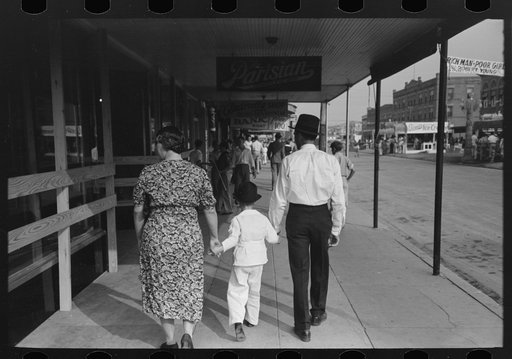 Untitled photo, possibly related to: After the parade is over people follow the line of it, walking down the middle of the street, National Rice Festival, Crowley, Louisiana