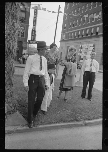 Untitled photo, possibly related to: After the parade is over people follow the line of it, walking down the middle of the street, National Rice Festival, Crowley, Louisiana