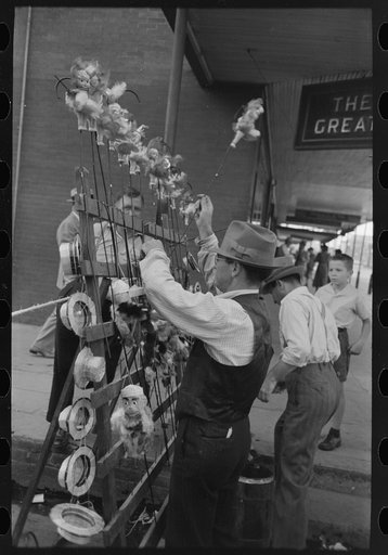 Concessionaire placing doll canes in rack, National Rice Festival, Crowley, Louisiana