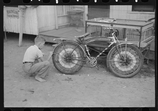 Boy decorating bicycle for entering contest for best decorated bicycle, National Rice Festival, Crowley, Louisiana
