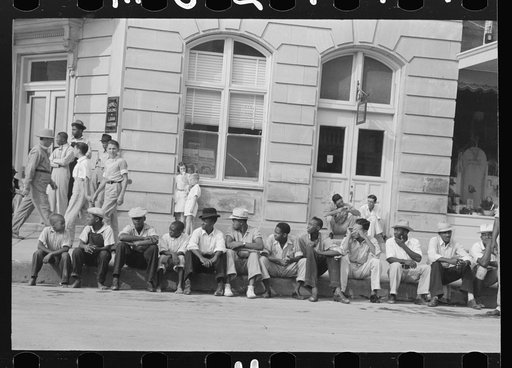 Negroes sitting on the curb waiting for the parade, National Rice Festival, Crowley, Louisiana