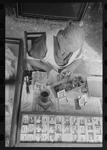 Wife of traveling photographer tinting small portraits, National Rice Festival, Crowley, Louisiana