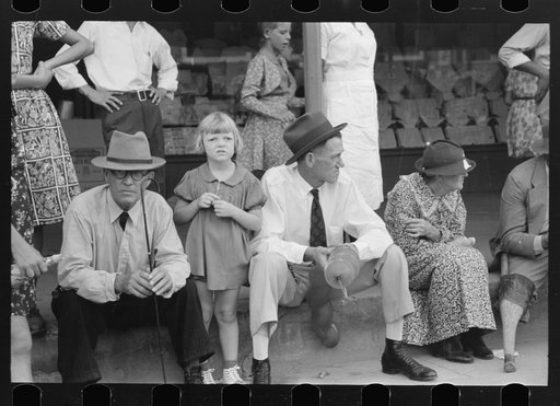 People sitting on sidewalk waiting for parade, National Rice Festival, Crowley, Louisiana