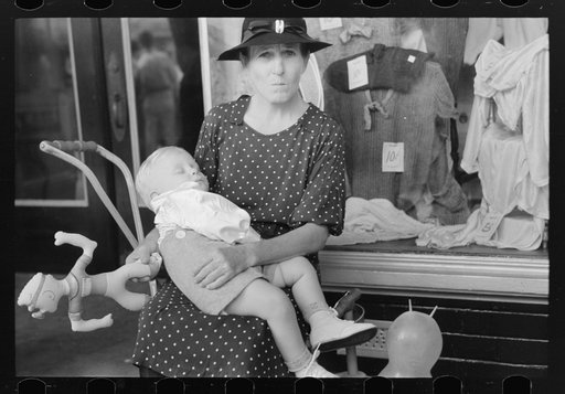 Woman with child in front of store during National Rice Festival, Crowley, Louisiana