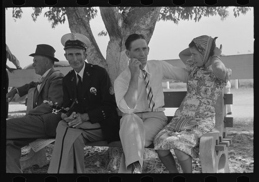 People sitting on bench, state fair, Donaldsonville, Louisiana