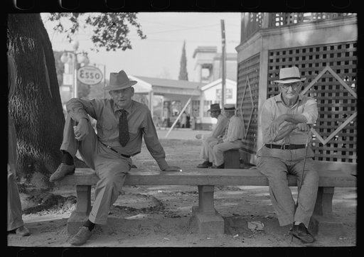 Men sitting on bench in front of bandstand in courthouse square, New Iberia, Louisiana