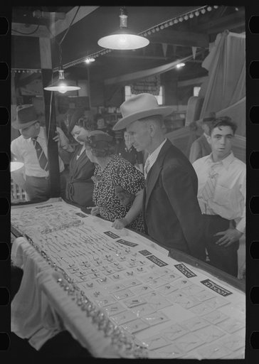 Untitled photo, possibly related to: Man and woman looking at display of cheap jewelry, state fair, Donaldsonville, Louisiana
