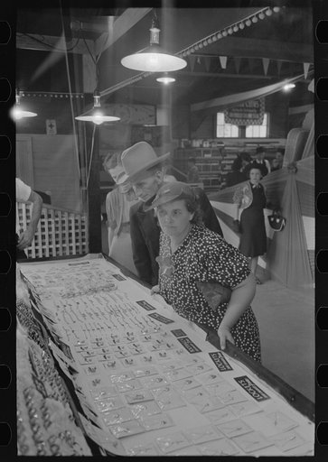 Man and woman looking at display of cheap jewelry, state fair, Donaldsonville, Louisiana