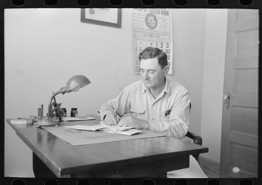 Untitled photo, possibly related to: Joseph La Blanc at the desk in his office, reading morning mail, near Crowley, Louisiana