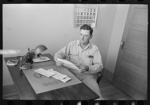 Joseph La Blanc at the desk in his office, reading morning mail, near Crowley, Louisiana