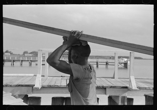 Untitled photo, possibly related to: Negro stevedore handling lumber in unloading process, Pilottown, Louisiana, the "El Rito"