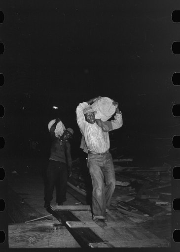 Untitled photo, possibly related to: Negro stevedores handling drum, New Orleans, Louisiana