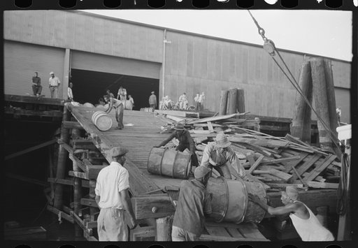 Untitled photo, possibly related to: Negro stevedores "snaking" drums down ramp to boat, New Orleans, Louisiana