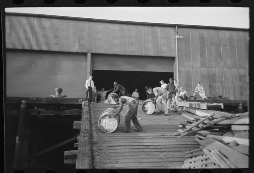 Untitled photo, possibly related to: Negro stevedores "snaking" drums down ramp to boat, New Orleans, Louisiana