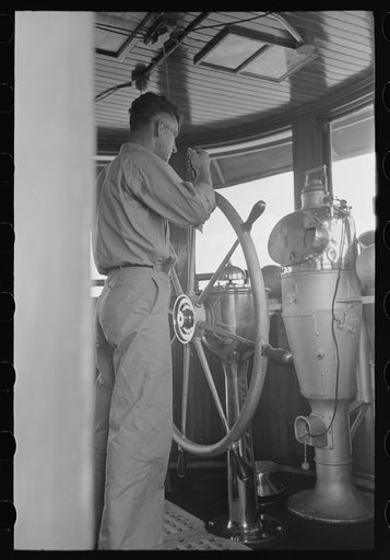 Untitled photo, possibly related to: Captain of tugboat at the wheel, lower Mississippi River