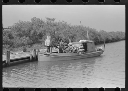 Oyster fisherman's boat at dock in canal, Olga, Louisiana