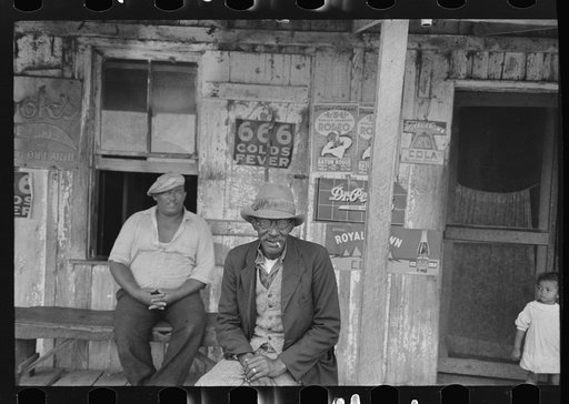 Untitled photo, possibly related to: Negroes talking on porch of small store near Jeanerette, Louisiana