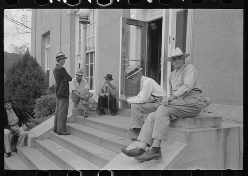 Men sitting on steps of post office, Lafayette, Louisiana