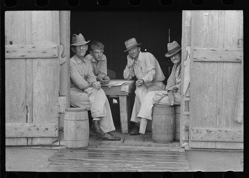 Group of men in a shack on the levee near Norco, Louisiana. They were taking refuge from the rain