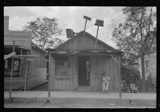 Man sitting in front of small store, Opelousas, Louisiana