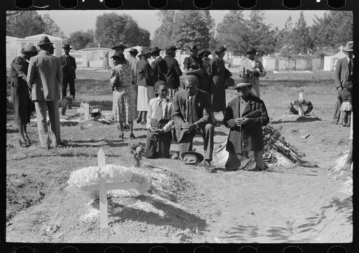 Negro family praying at graves of their relatives on All Saints' Day, New Roads, Louisiana