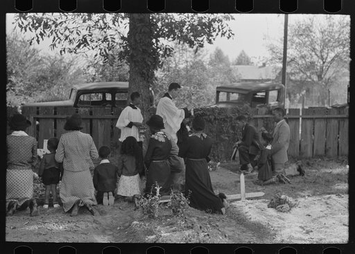 Negro family praying at graves of their relatives on All Saints' Day, New Roads, Louisiana