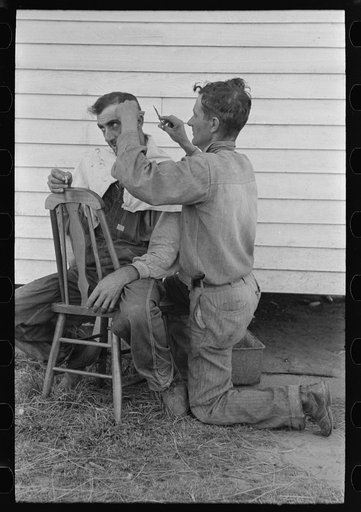 Untitled photo, possibly related to: Cajun sugarcane farmer cutting hair of neighboring farmer near New Iberia, Louisiana