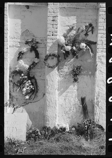 Decorations on side of family burial vault in cemetery at New Roads, Louisiana on All Saints' Day