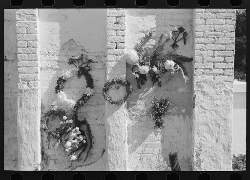 Untitled photo, possibly related to: Decorations on side of family burial vault in cemetery at New Roads, Louisiana on All Saints' Day